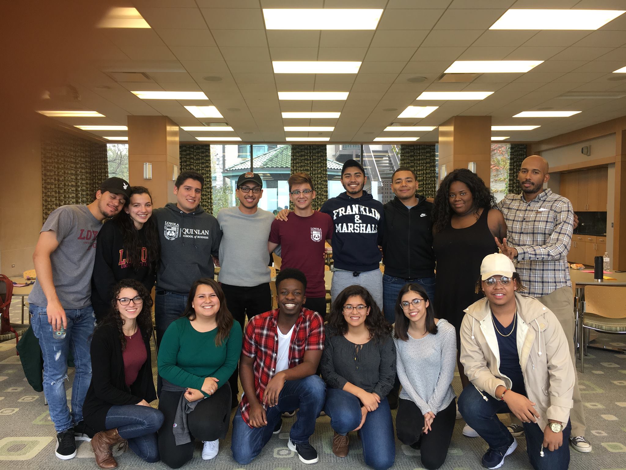 Loyola University Chicago Christo Rey academic scholars. Straight-on shot of 15 diverse students in two rows, smiling.